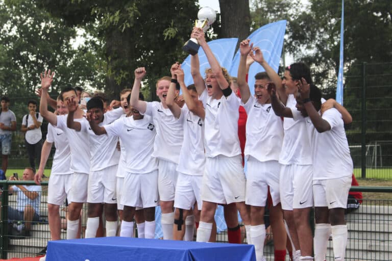 Fussballmannschaft feiert Sieg mit goldenem Pokal